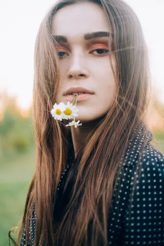 咬着白色雏菊花的女人