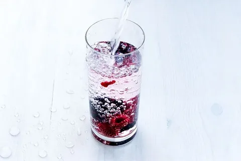 在白色背景下，水在玻璃中飞溅的特写镜头