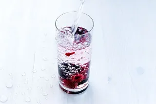 在白色背景下，水在玻璃中飞溅的特写镜头