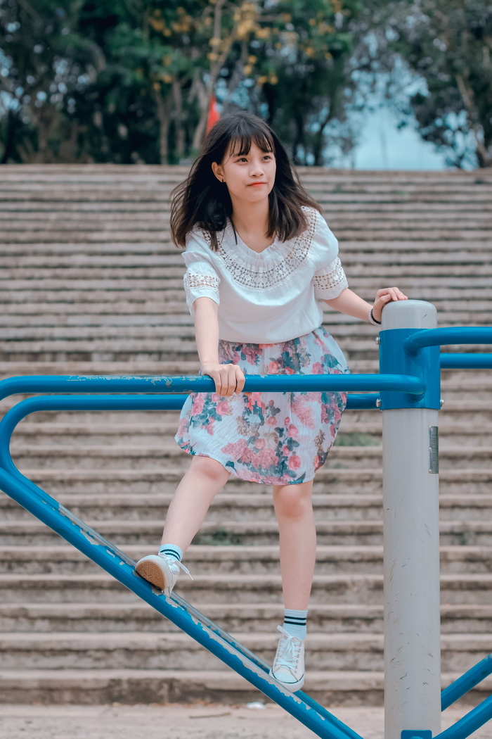 身穿白色上衣和五彩花裙的女子骑着旋转木马