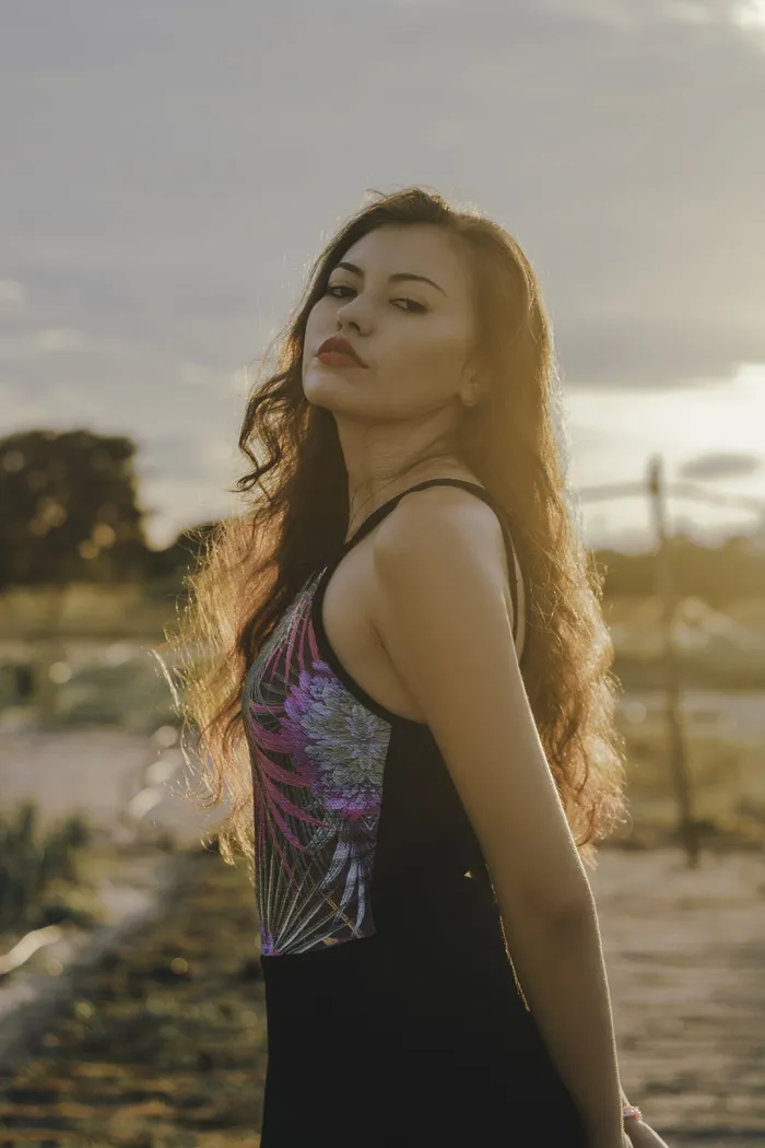 身穿黑色服装的女子在外面摆姿势的侧视照片