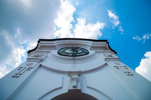 蓝天下的白色混凝土建筑，带时钟