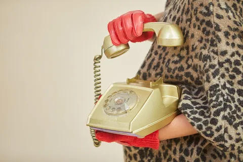 手持金色旋转电话的人