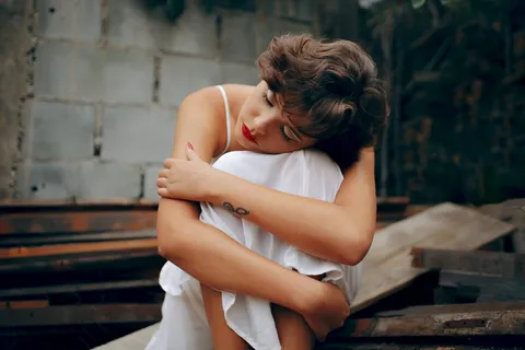 蹲在灰色混凝土墙附近的女人