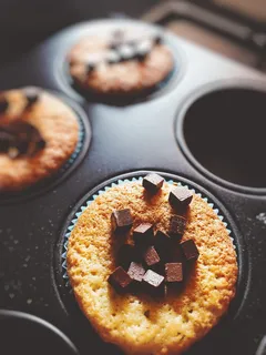 顶部有巧克力块的纸杯蛋糕