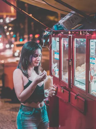 红色木框玻璃展示台附近的一名妇女拿着透明塑料袋