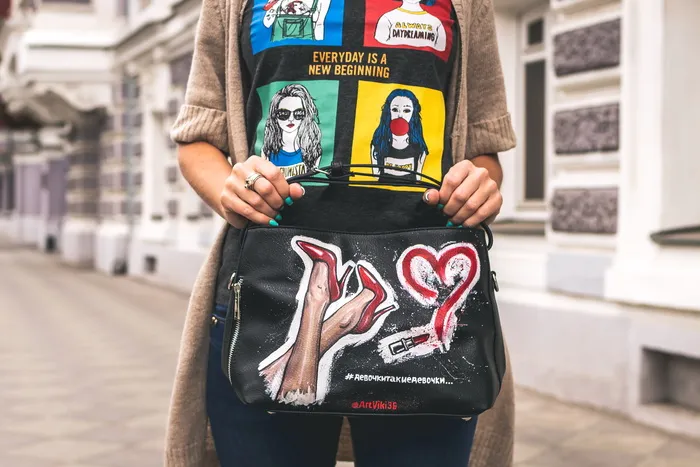 拿着黑色皮包的人的浅焦照片