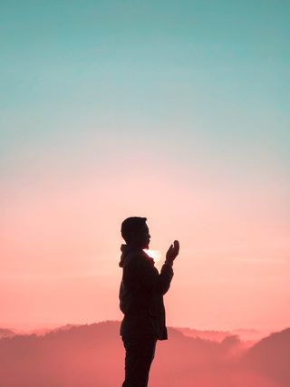 黄金时段男子举手的剪影