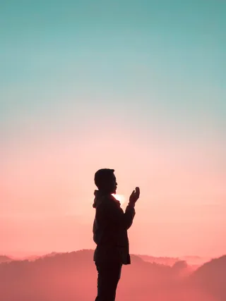 黄金时段男子举手的剪影