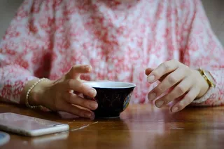 拿着黑杯子的女人