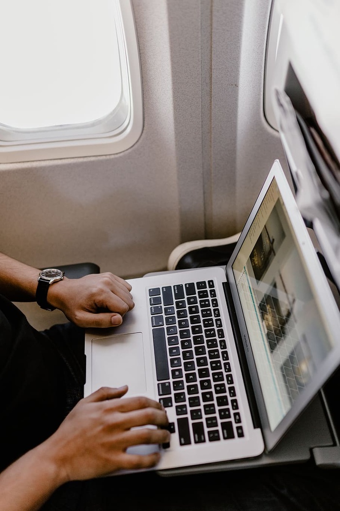 坐在飞机里的一个拿着笔记本的面目全非的男人