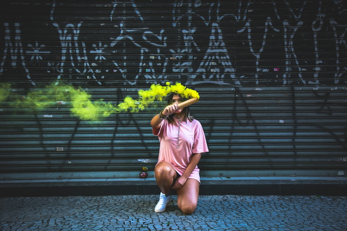 举着绿色烟雾标志的女人