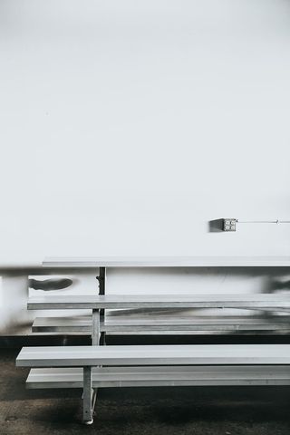 白墙附近的灰色长凳