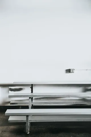 白墙附近的灰色长凳