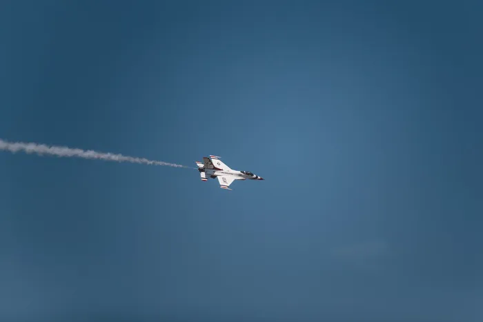 带有白烟轨迹的白色喷气式飞机