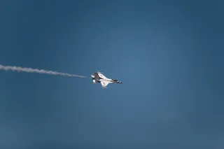 带有白烟轨迹的白色喷气式飞机