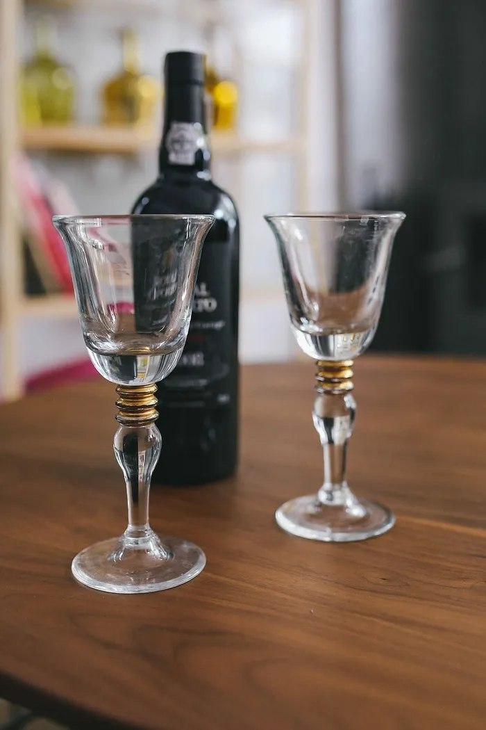 桌子上放着两个空酒杯和一瓶葡萄酒