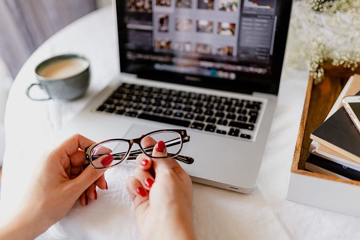 一位女士在一张桌子旁工作，桌上有一台笔记本电脑和一杯咖啡