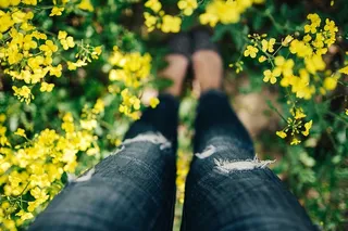 在盛开的油菜地里拿着老式相机的女人