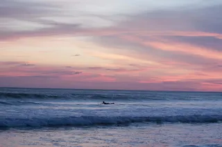 日落时冲浪人的全景摄影