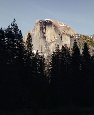 穿过树林的山峰照片