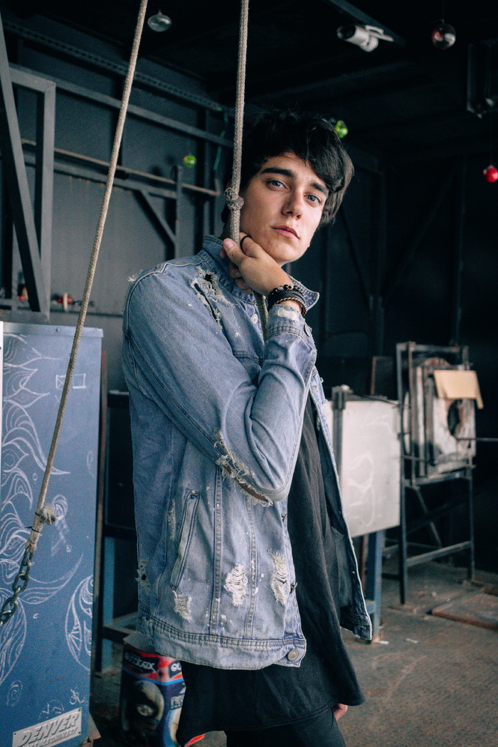 男子穿着牛仔夹克，手持绳索