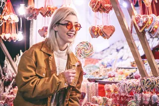 女人在夜间微笑时拿着棒棒糖