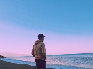 穿着连帽衫的男子站在海边