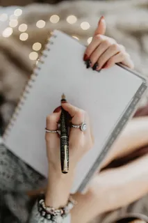 躺在床上的笔记本上写东西，里面有咖啡、蜡烛和姜饼