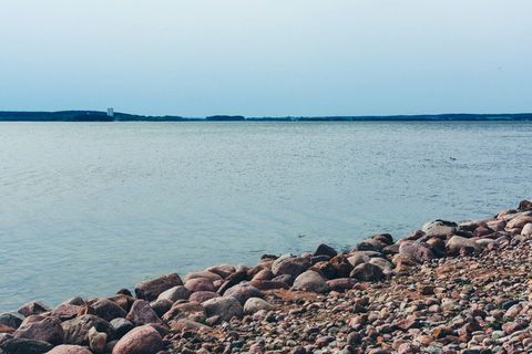 蓝天下的水体旁的岩石地段