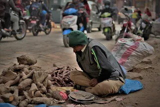一名男子坐在路边的浅焦照片