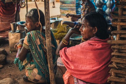 一个靠着棕色墙壁坐着的女人