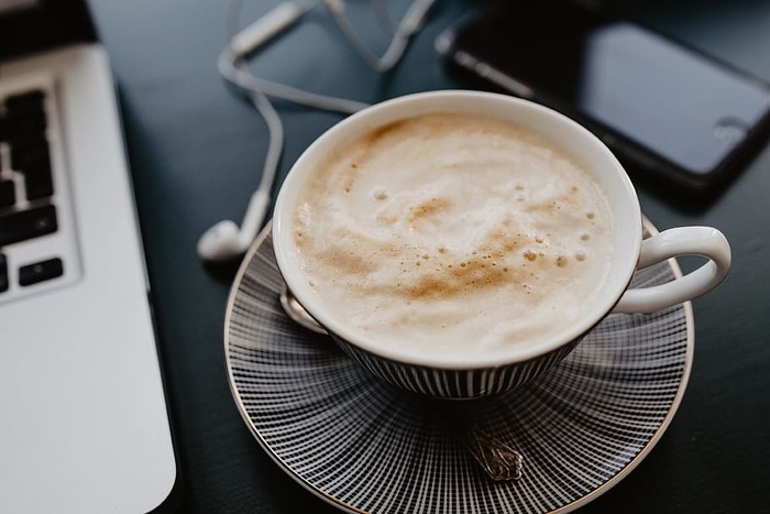 男性用笔记本电脑和一杯咖啡工作