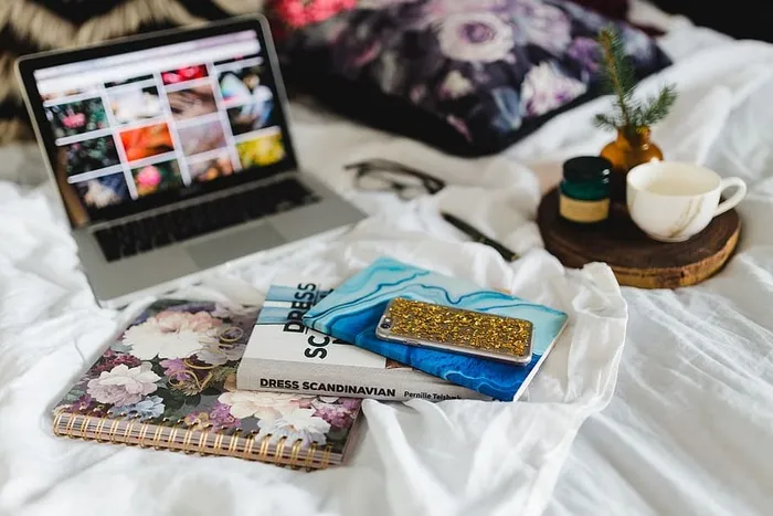 床上放满了枕头和带苹果小玩意的笔记本