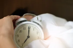 拿着闹钟的人的照片