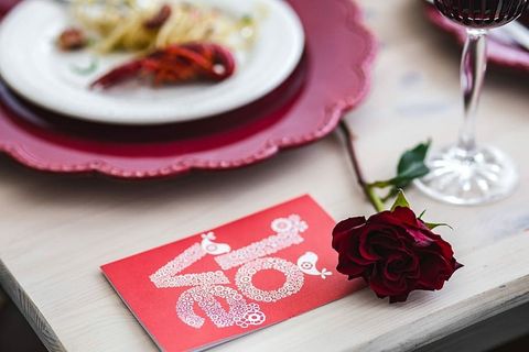 精美的晚餐，搭配海鲜意大利面、小龙虾和红酒，餐桌上装饰着玫瑰