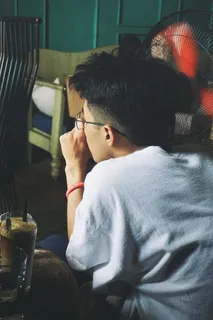 坐在风扇旁边的男人 坐在风扇旁边的男人