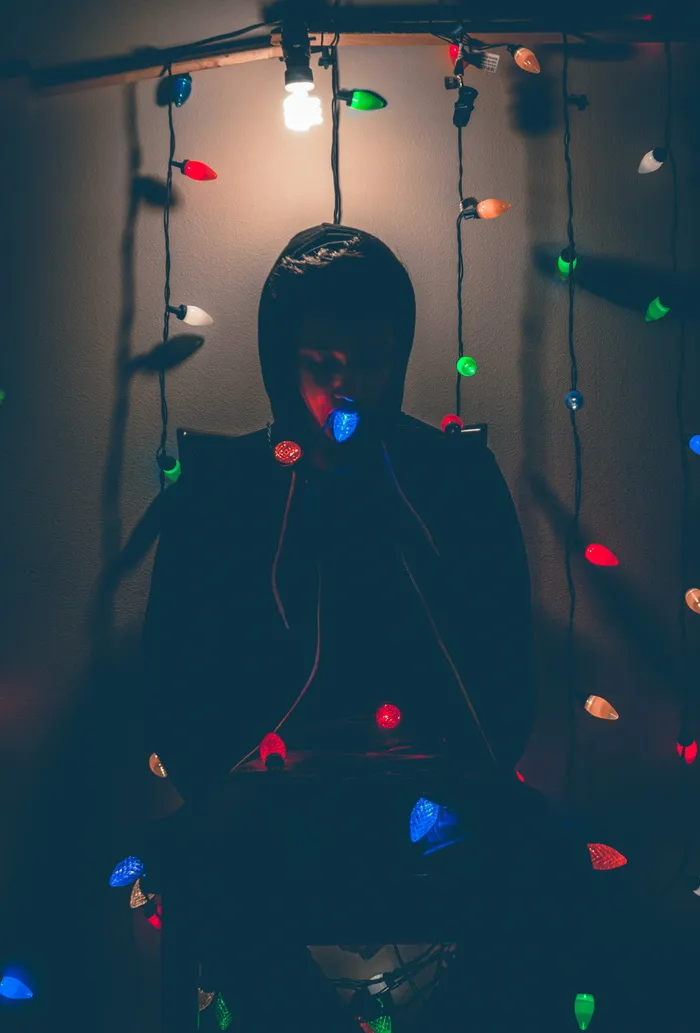 坐在椅子上的男人用多色灯串