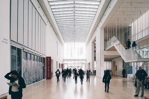 沿着混凝土建筑走廊的人们 沿着混凝土建筑走廊的人们