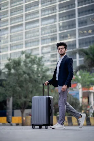 一名男子沿水泥路拉行李的选择性聚焦摄影