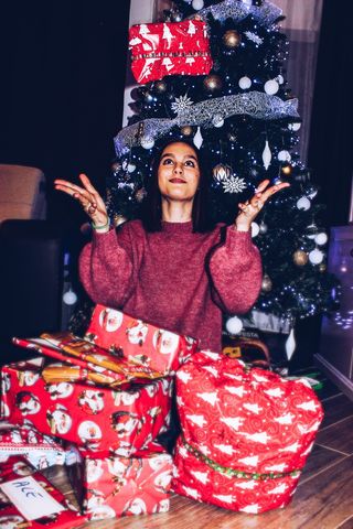 女人在圣诞树附近收到礼物