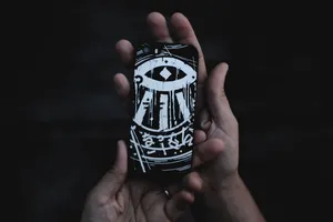 手持黑白手机壳的人