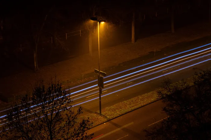 黑色柏油路之间的灰色路灯柱