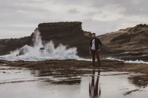 站在海浪附近泥土上的男子 站在海浪附近泥土上的男子