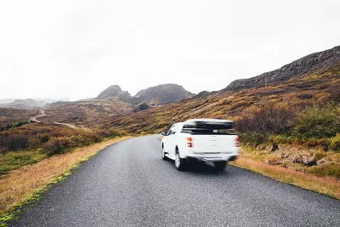 模糊的皮卡车在公路上行驶，背景是山脉