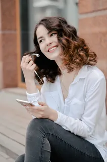 穿着白色衬衫手持智能手机的女士 穿着白色衬衫手持智能手机的女士