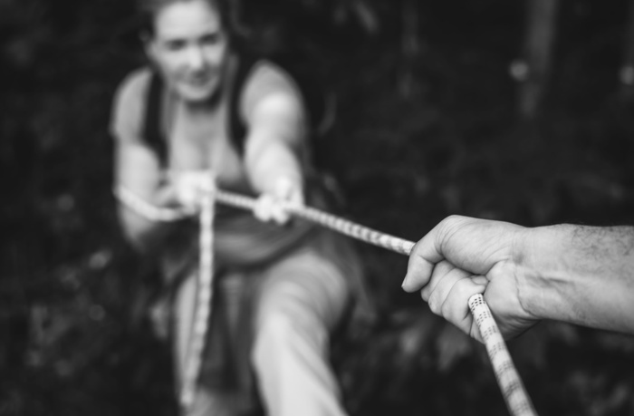 用绳子把女人拉起来的灰度照片