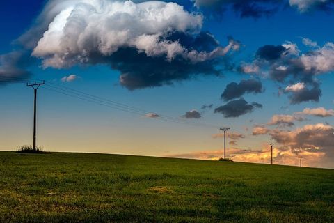 傍晚时分，蔚蓝的天空和大片的云朵点缀着一片神奇的草地