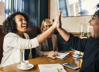 笑着坐在桌子前击掌的女人