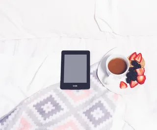 白色织物上的黑色Kindle电子书阅读器